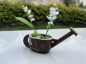 arrosoir en chocolat avec deux pots de muguet